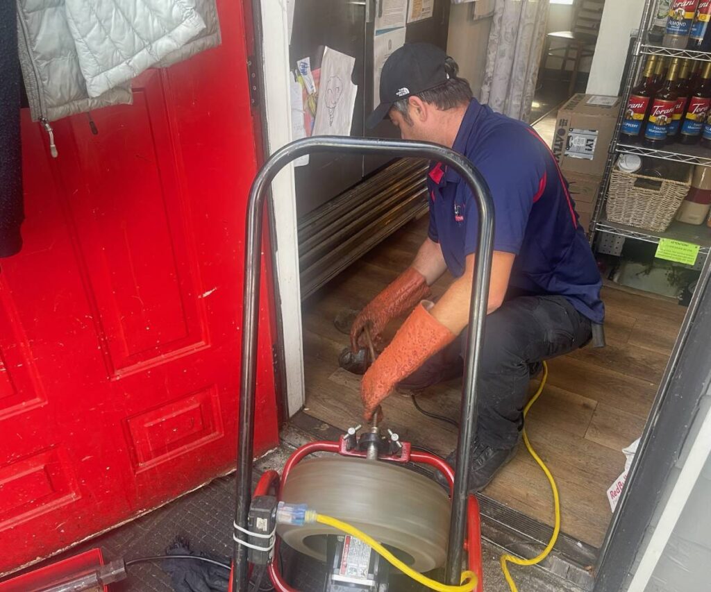 KnightRooter plumber performing hydro jetting on a clogged kitchen drain in Seattle, WA