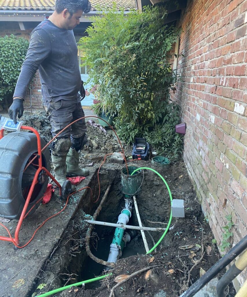 KnightRooter technician performing camera inspection with satisfied homeowner