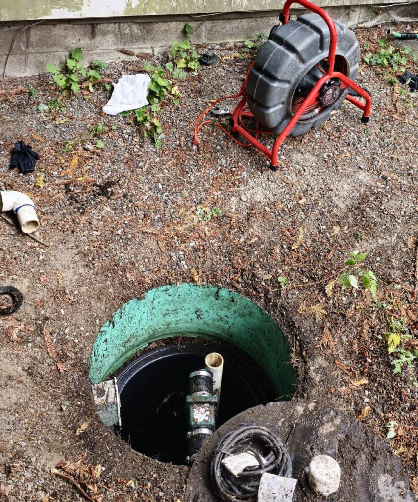 KnightRooter technician performing sewer camera inspection via cleanout in Seattle backyard