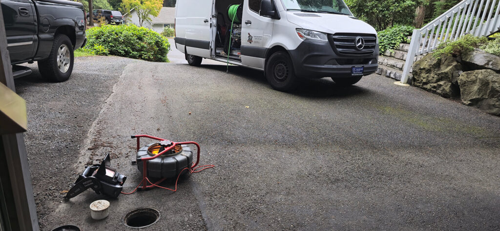 Sewer camera entering cleanout with Seattle backyard in background